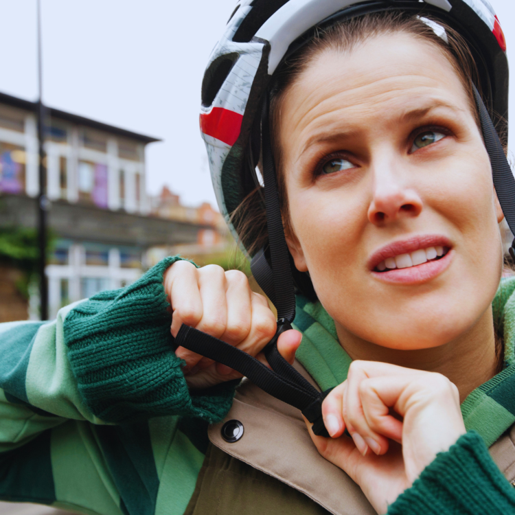 Jeune femme qui ajuste son casque de vélo