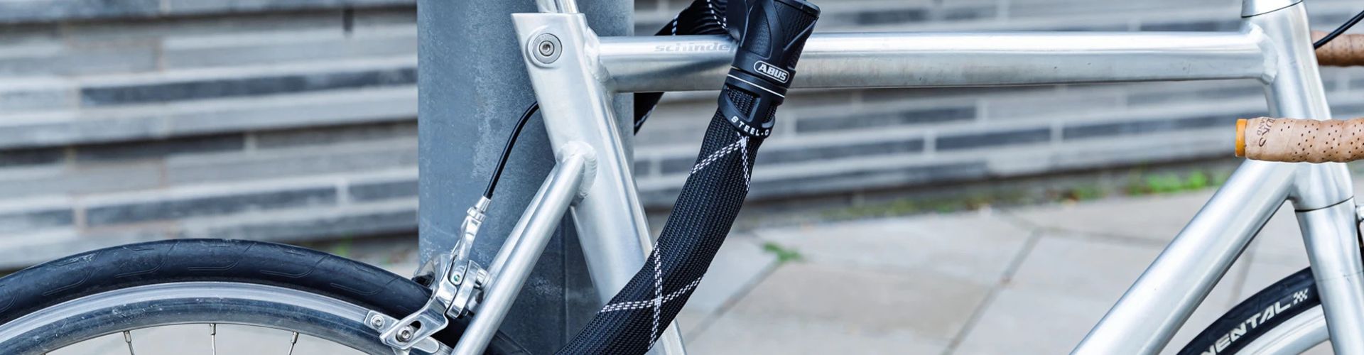 antivol chaine ABUS acroché à un vélo et à un poteau