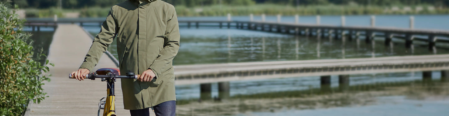 Homme avec une parka à côté de son vélo