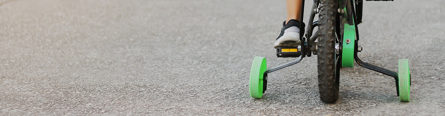 Zoom sur l'arrière d'un vélo enfant équipé de roues stabilisatrices