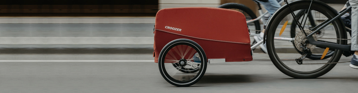 remorque cargo rouge derrière un vélo