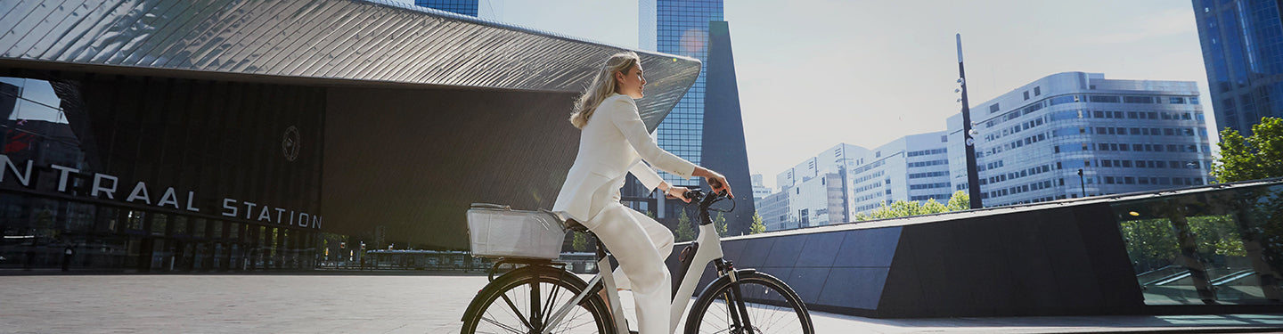 Femme sur son vélo avec un panier arrière sur le porte-bagages