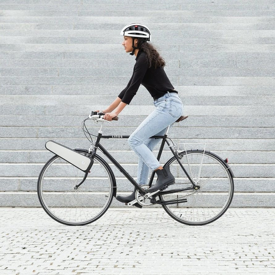 Femme en ville utilisant le moteur electrique portable Clip Bike Explorer 192 Wh de la marque 125 sur velo classique