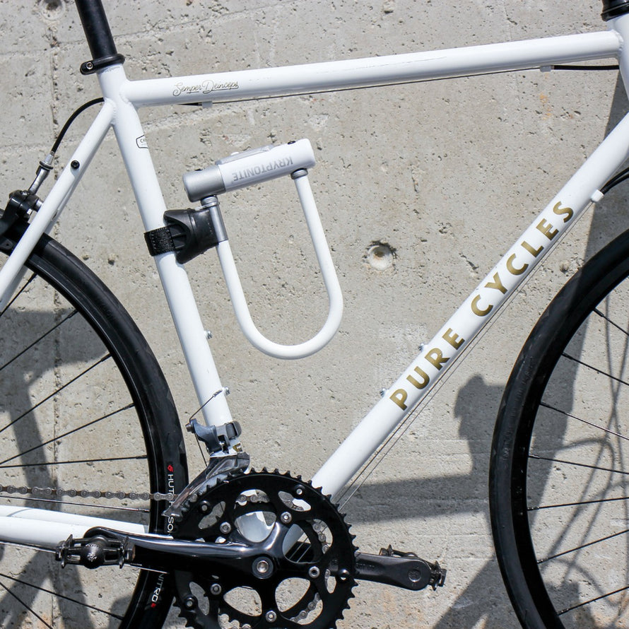 Antivol vélo Kryptolok Mini 7 blanc de Kryptonite fixé sur cadre de vélo blanc Pure Cycles