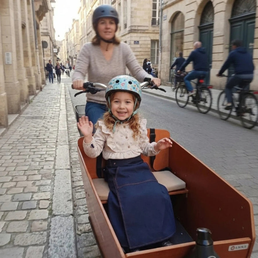Enfant souriant protege par couverture velo chaude et impermee Dryfits Kids JUP-ON sur velo cargo
