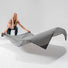 Femme deploie la couverture grise Matador Pocket Blanket, legere et compacte pour toutes activites outdoor