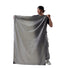 Homme tenant la couverture de poche Matador Pocket Blanket dépliée, idéale pour activités outdoor et protection au sol