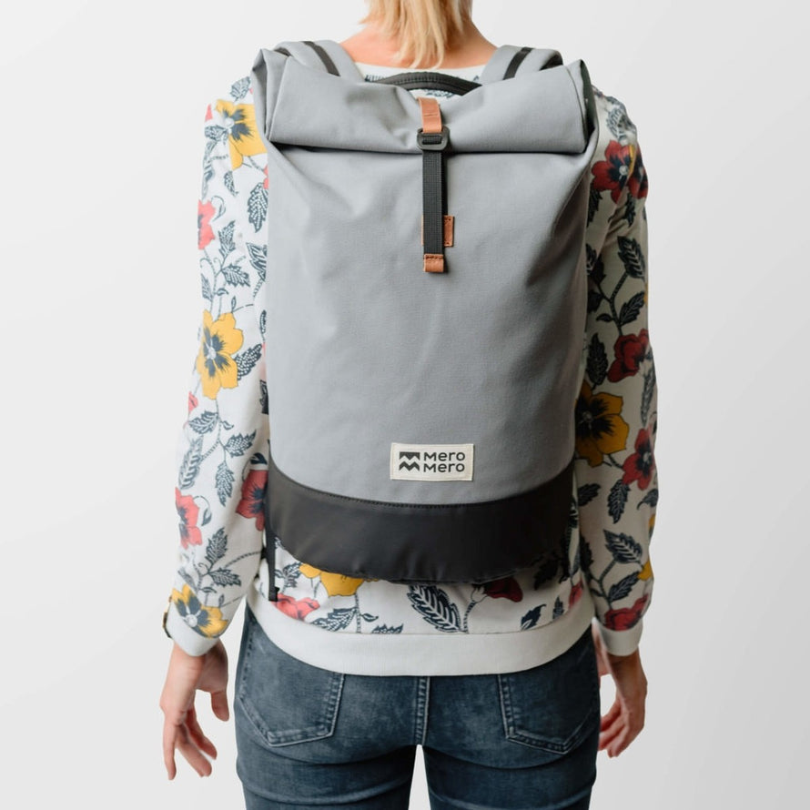 Sac a dos imperméable roll-top MeroMero Wanaka gris porté par femme, parfait pour trajets urbains à vélo