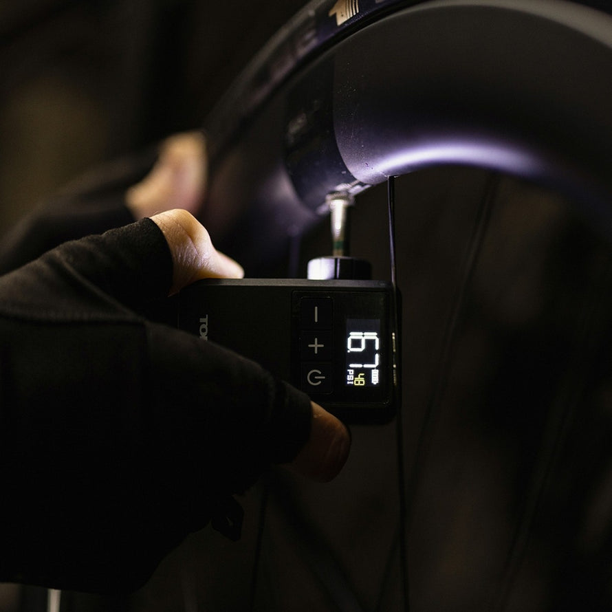 Mini compresseur Topeak E-Booster Digital Mini en action pour gonfler un pneu de vélo avec précision numérique