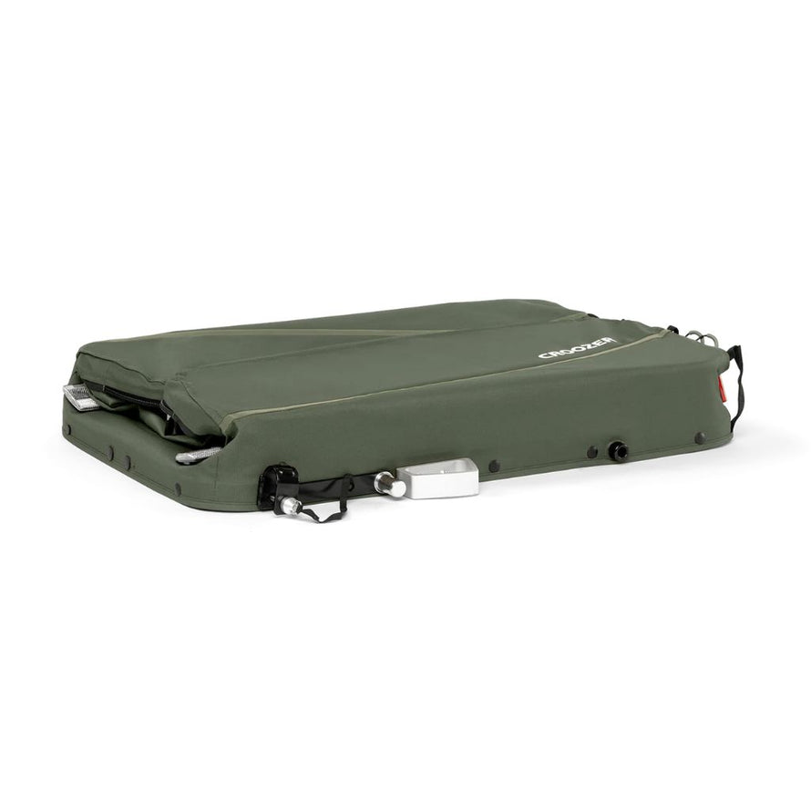Remorque Croozer Kalle pliée pour un rangement compact dans un appartement ou un local vélo.