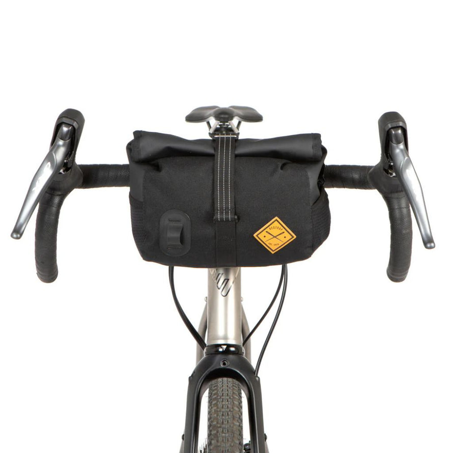 Sacoche de guidon Restrap Rolltop Canister installée à l’avant d’un vélo gravel.