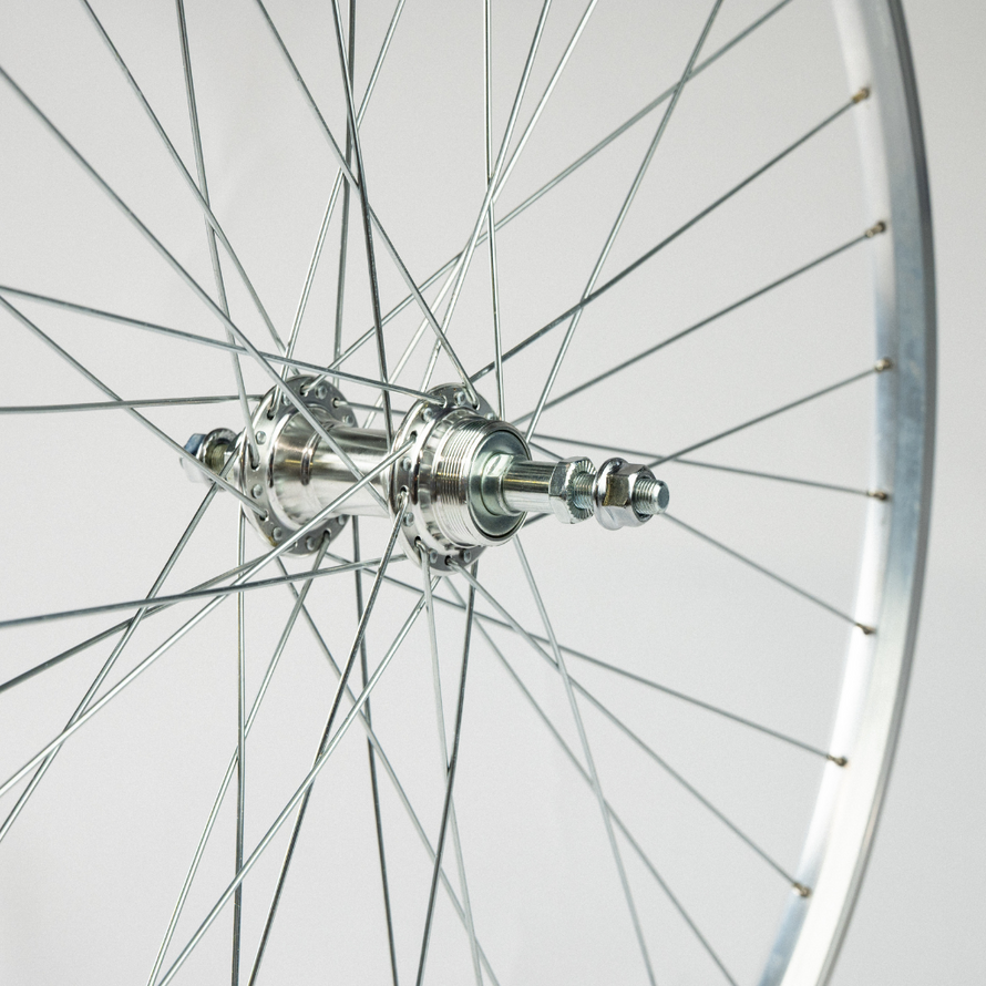 Zoom sur le moyeu argenté de la roue arrière, avec détails des rayons fixés autour de l’axe central.
