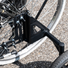 Zoom sur le système de fixation des roues stabilisatrices d’un vélo adulte, fixé au niveau du hauban et de la base arrière du cadre.