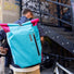 Sacoche vélo convertible sac à dos Vario Ortlieb en bleu et rose portée en ville près d'un escalier