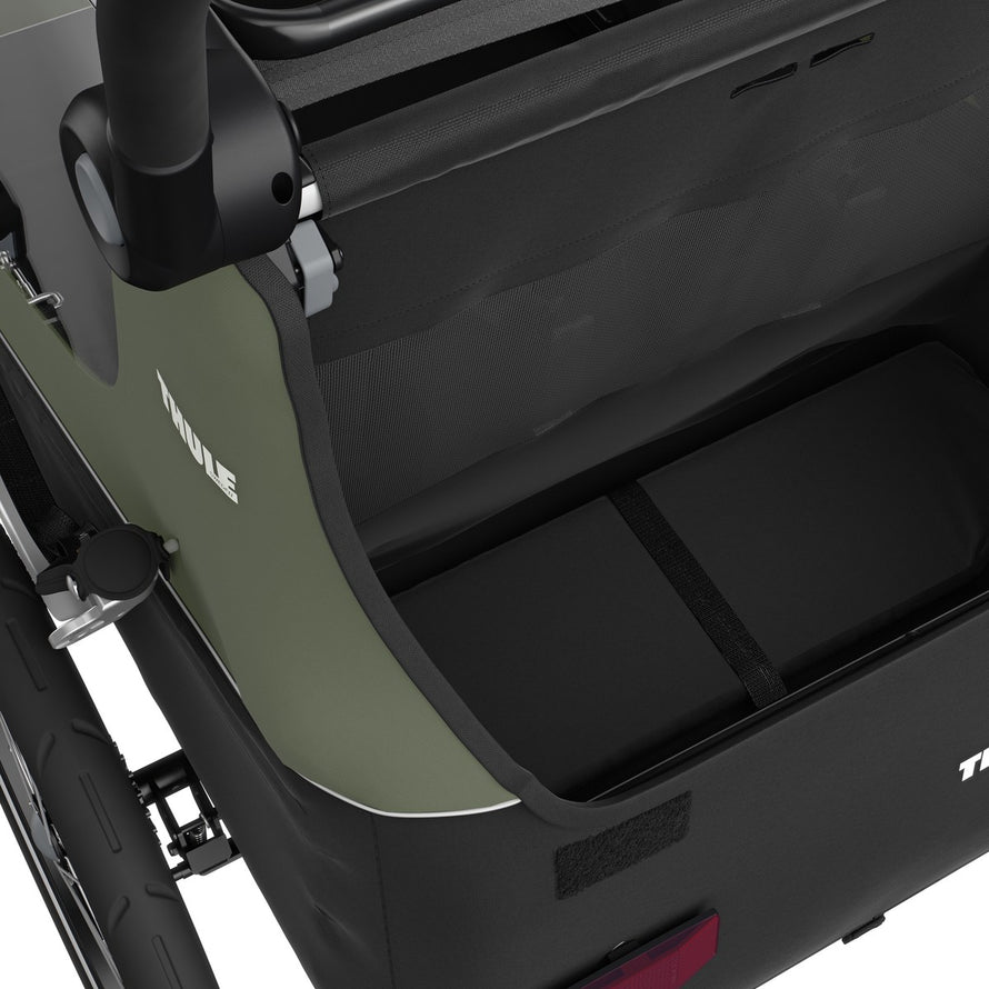 Intérieur de la remorque enfant Thule Courier 2 places en olive avec siège confortable et harnais sécurisé