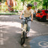 Femme en t-shirt Vaude Cyclist Casual beige à vélo en milieu urbain, style décontracté et écologique