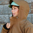 Portrait rapproché d’une femme avec la veste Imbris camel et capuche ajustée, mettant en avant les finitions haut de gamme.