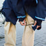Gros plan sur un homme ajustant la sangle de jambe innovante de la veste Imbris marine, conçue pour garder les genoux au sec.