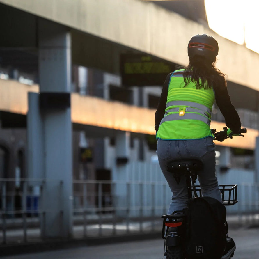 Lampe led magnétique Wowow Magnetlight 2.0 fixée sur un gilet réfléchissant pour cycliste en ville